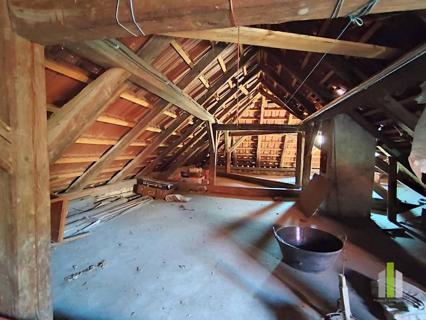 Geräumiger Dachboden mit sichtbaren Holzbalken und Dachkonstruktion, bietet Ausbaupotenzial.