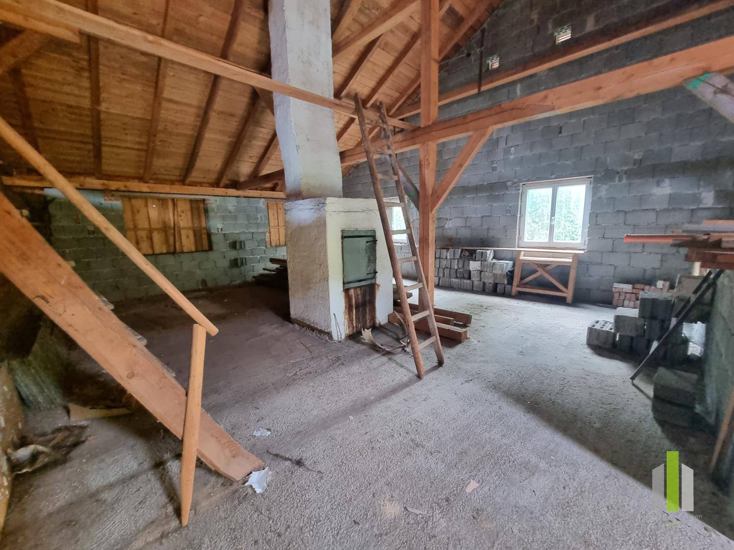 Unausgebauter Dachboden mit sichtbaren Holzbalken und Mauerwerk, bietet Ausbaupotenzial.