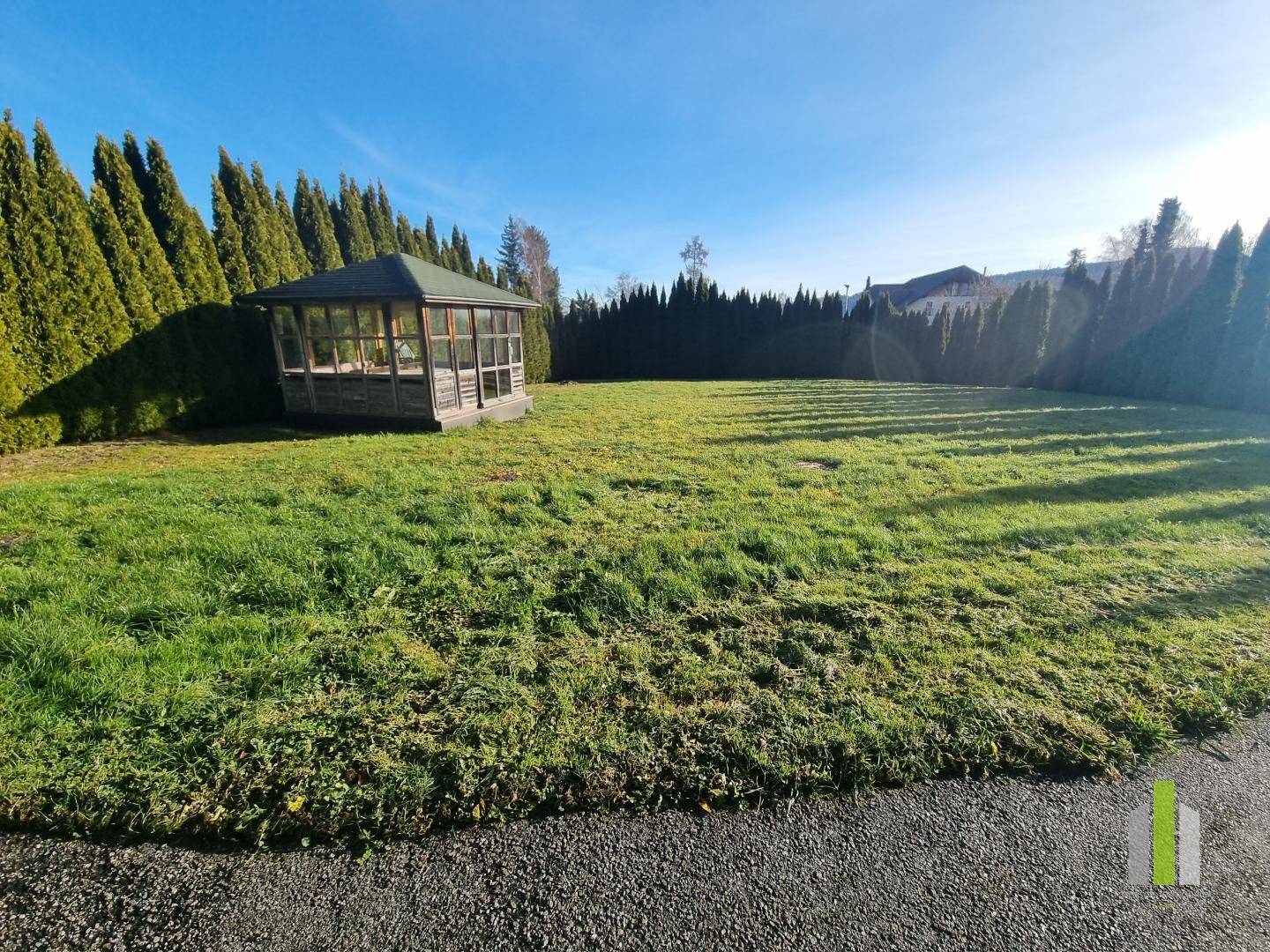 Großer, gepflegter Garten mit Rasenfläche und einem charmanten Holzpavillon.