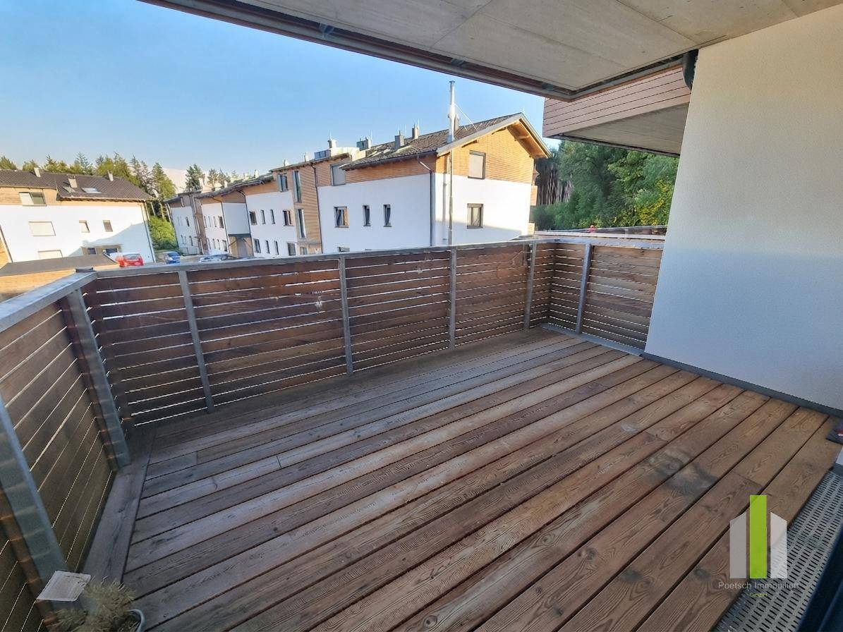 Geräumiger Balkon mit Holzboden und Sichtschutz, ideal für entspannte Stunden im Freien.