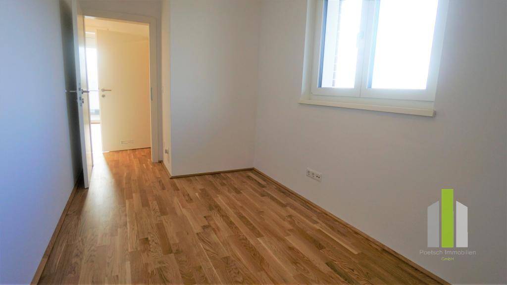 Helles Zimmer mit Holzboden und Fenster, ideal als Schlafzimmer oder Arbeitszimmer nutzbar.