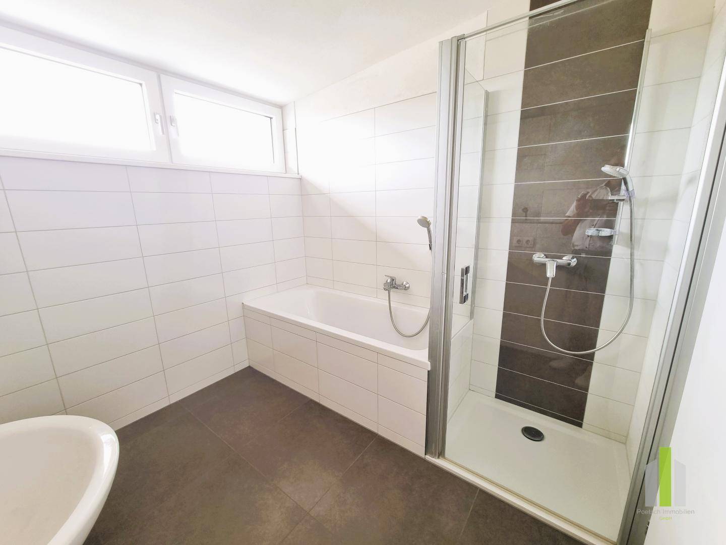 Helles Badezimmer mit Badewanne, begehbarer Dusche und Fenster für natürliche Belüftung.