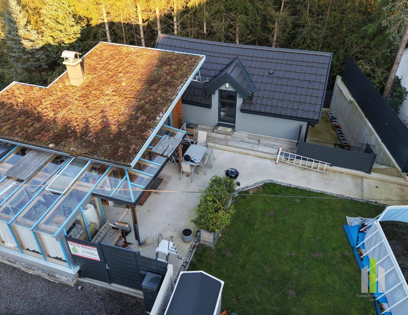 Luftaufnahme des Anwesens mit Gründach, Wintergarten, Terrasse und gepflegtem Gartenbereich.