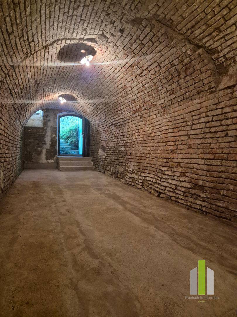 Historischer Gewölbekeller mit Ziegelwänden und Betonboden, der viel Stauraum bietet.