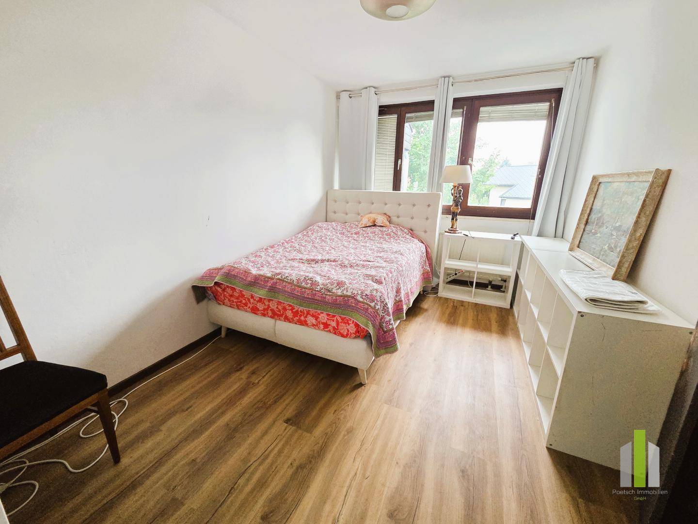 Gemütliches Schlafzimmer mit Einzelbett, Laminatboden und Fenster.