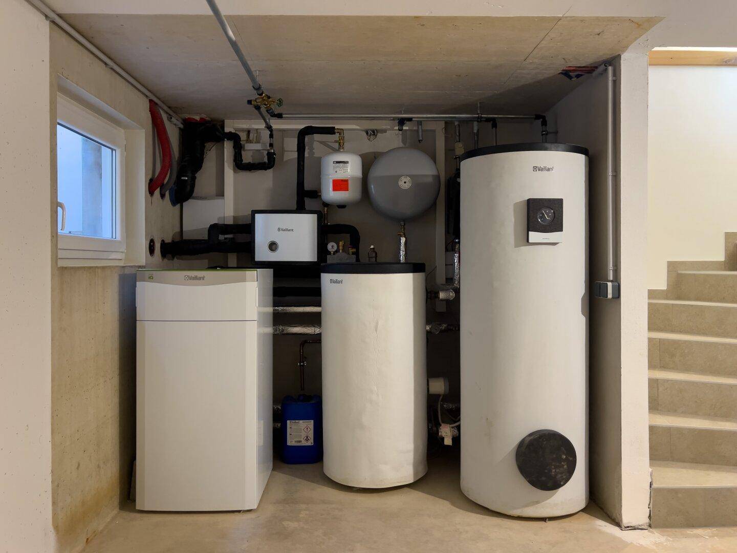 Technikraum im Keller mit moderner Heizungsanlage und Warmwasserspeichern.