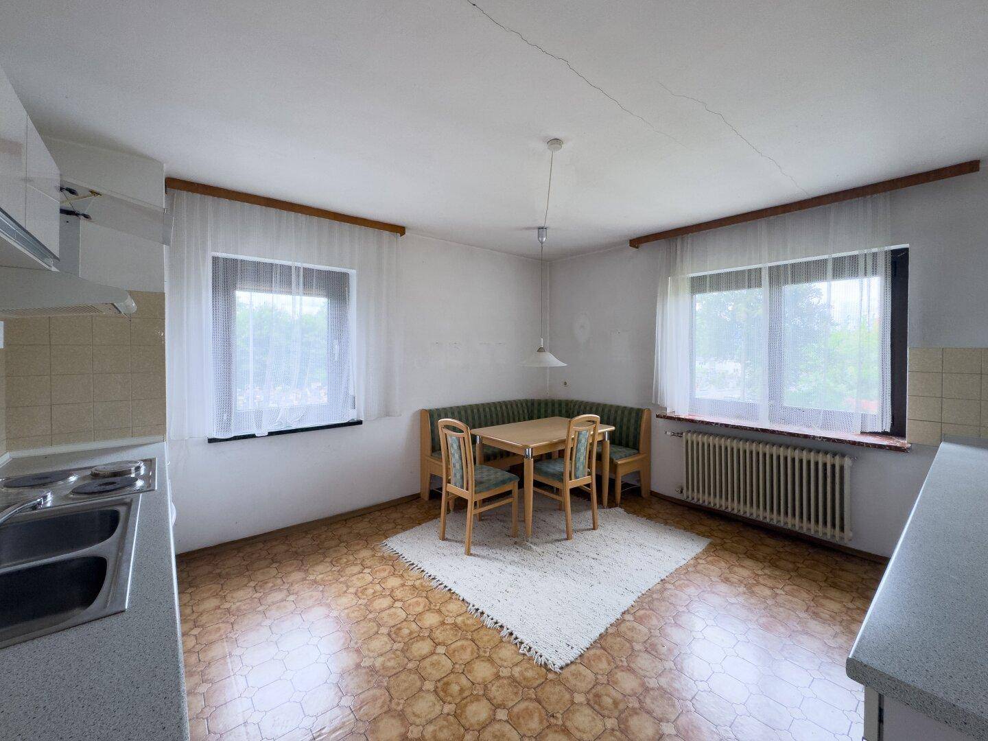 Wohnküche mit Essbereich und zwei Fenstern, bietet Platz für gemütliche Mahlzeiten.