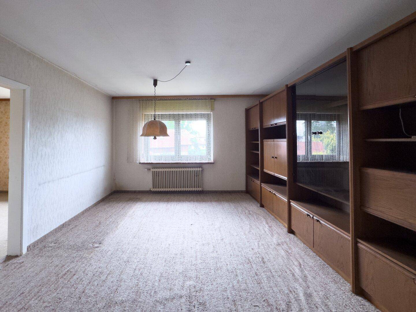 Helles Zimmer mit Teppichboden und Einbauschränken, bietet viel Stauraum.