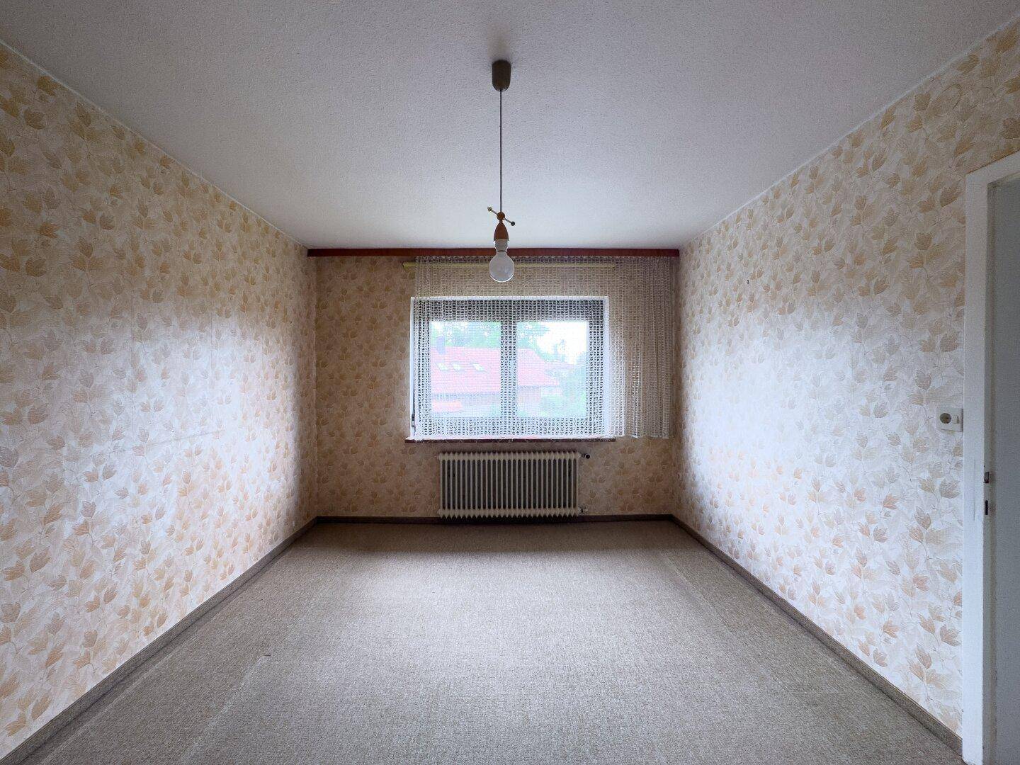 Schlafzimmer mit gemusterter Tapete und Teppichboden, bietet eine gemütliche Atmosphäre.