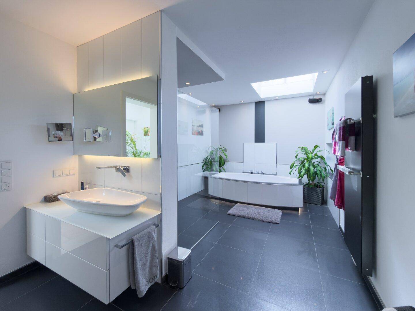 Großzügiges, lichtdurchflutetes Badezimmer mit moderner Ausstattung, Badewanne, Dusche und Waschtisch.