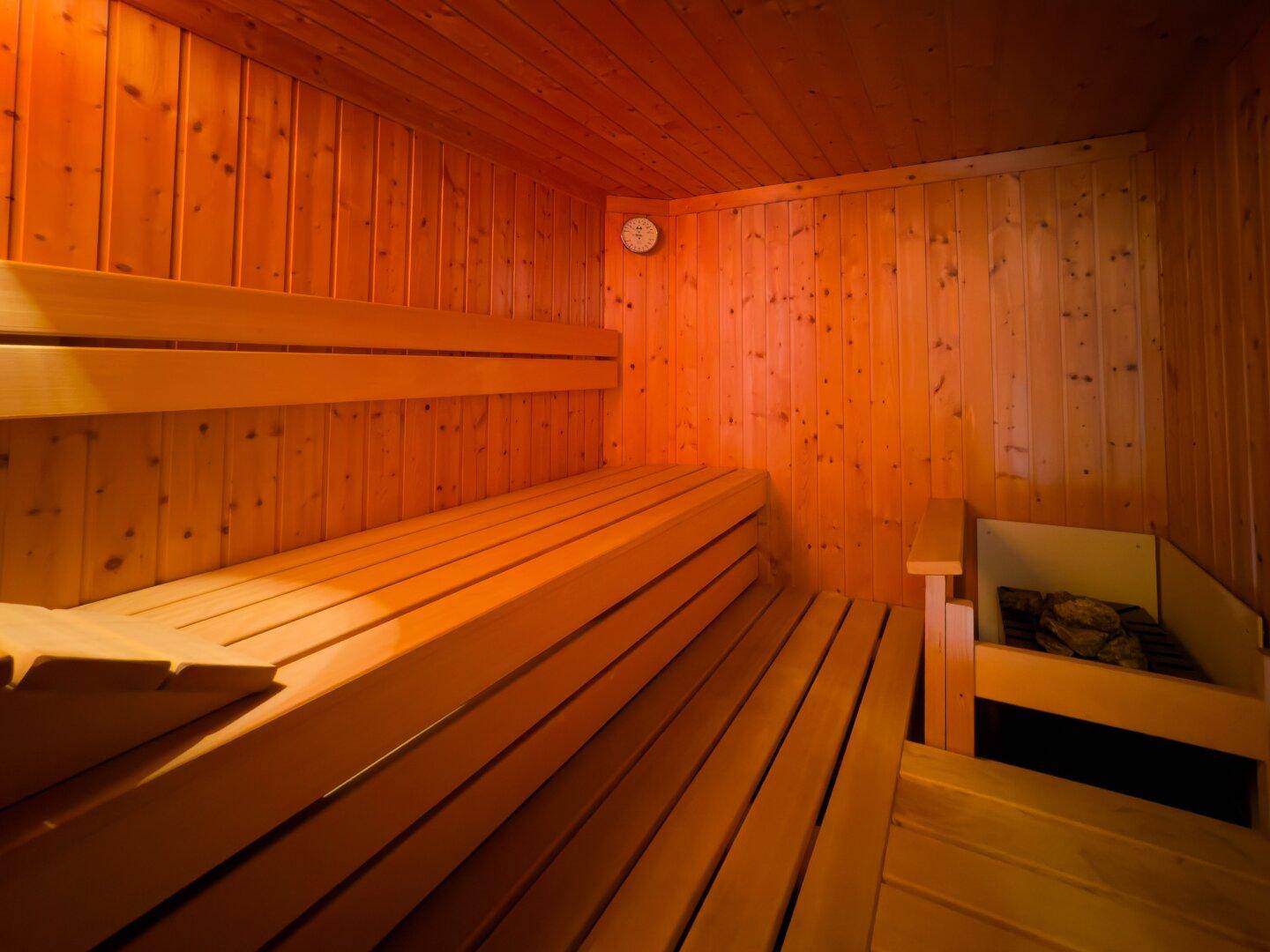 Traditionelle Holzsauna mit mehrstufigen Bänken und Saunaofen.