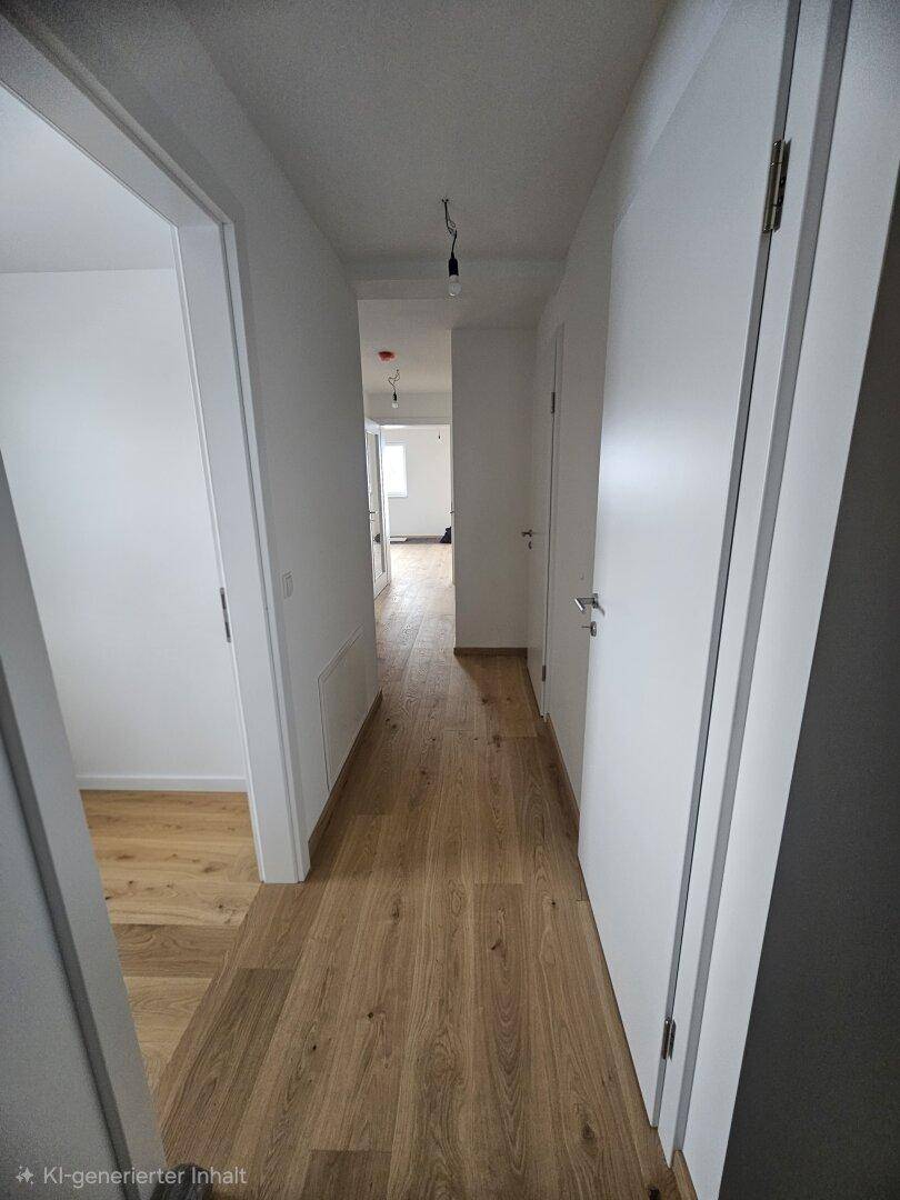 Heller Flur mit modernem Holzparkett und weißen Türen, der zu weiteren Räumen führt.