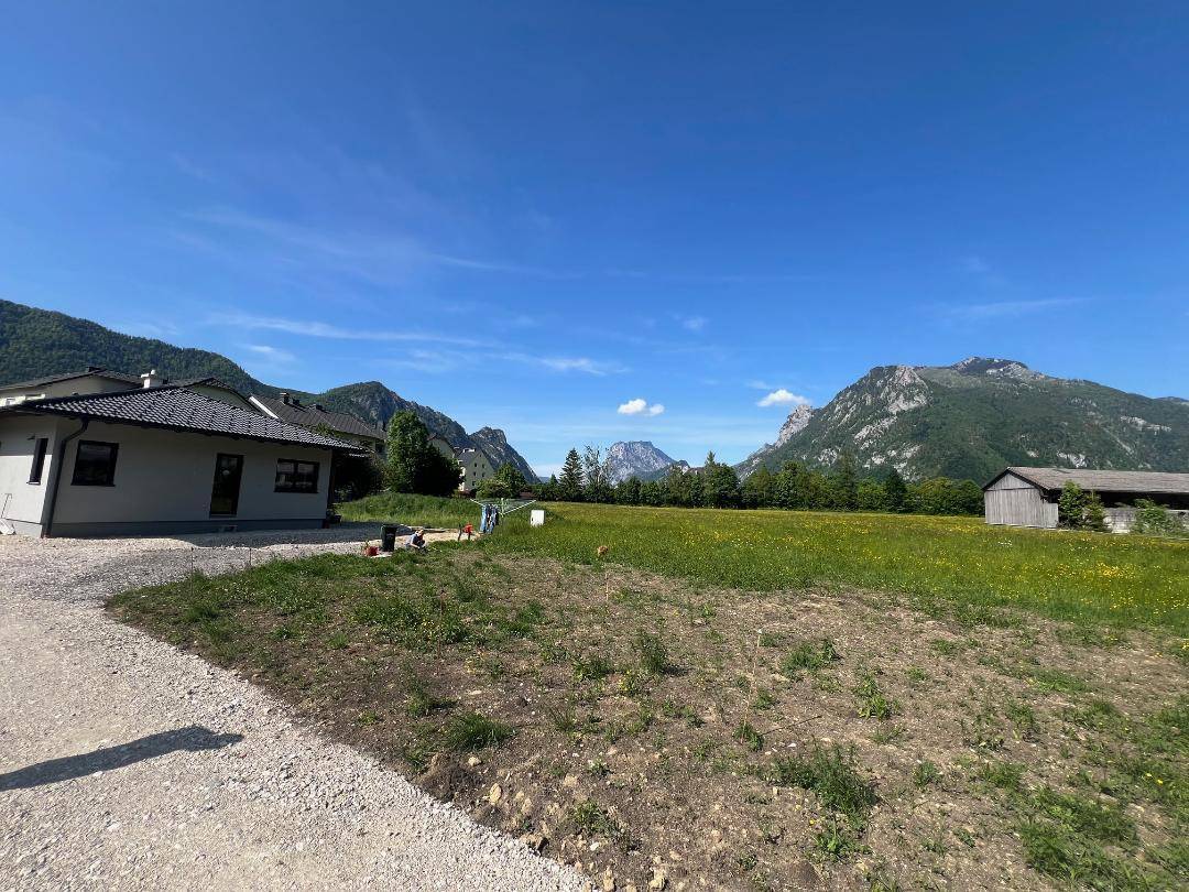 Ein modernes Haus mit Kiesauffahrt und weitem Blick auf die umliegende Berglandschaft.