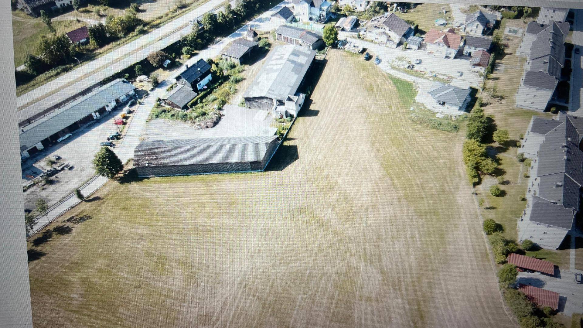 Luftaufnahme eines großen Grundstücks mit umliegenden Gebäuden und Straßen in ländlicher Umgebung.