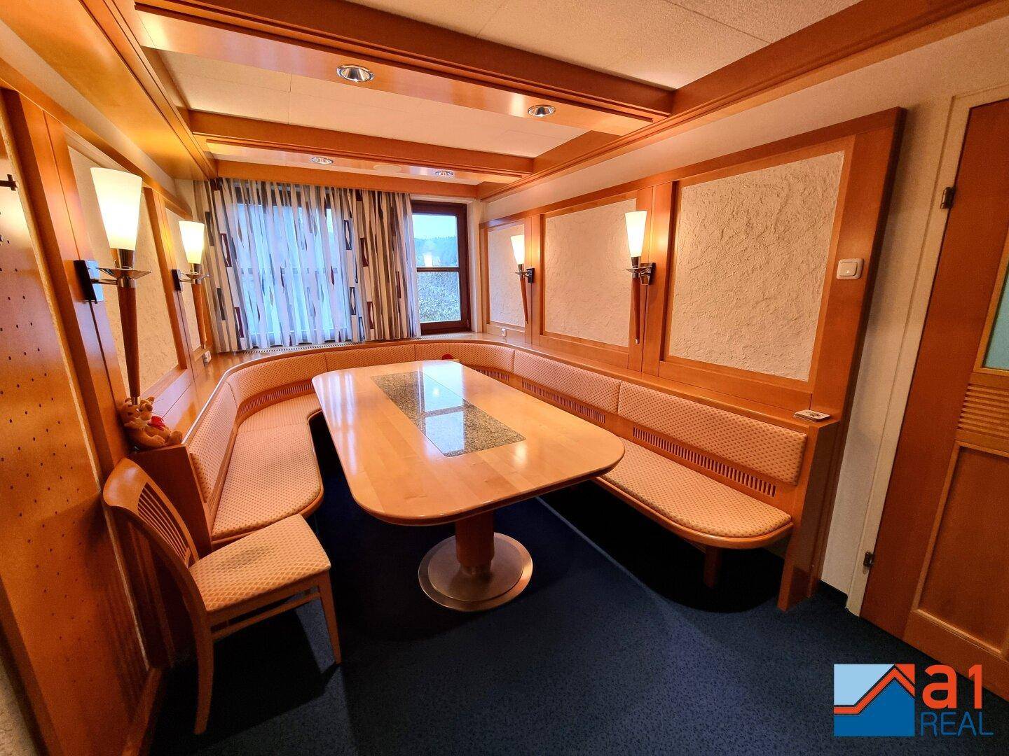 Gemütlicher Essbereich mit eingebauter Eckbank, Holztisch und Holzvertäfelung, ideal für gesellige Runden.