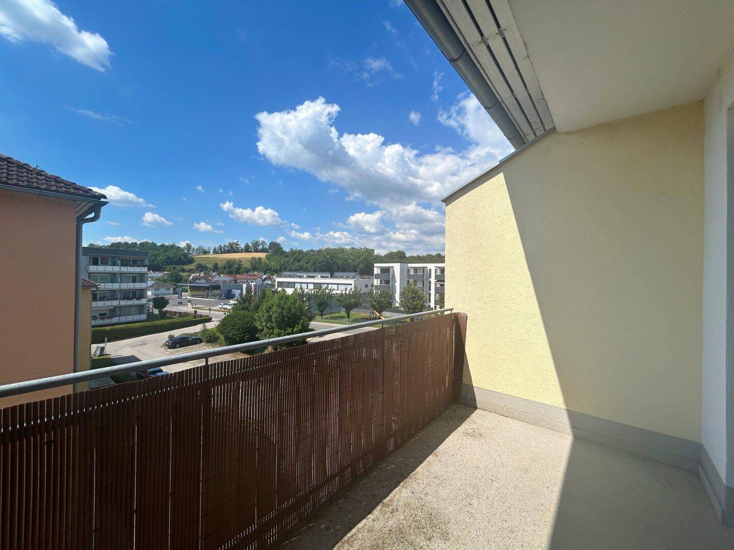 Sonniger Balkon mit Blick auf die Umgebung und andere Gebäude, ideal zum Entspannen.