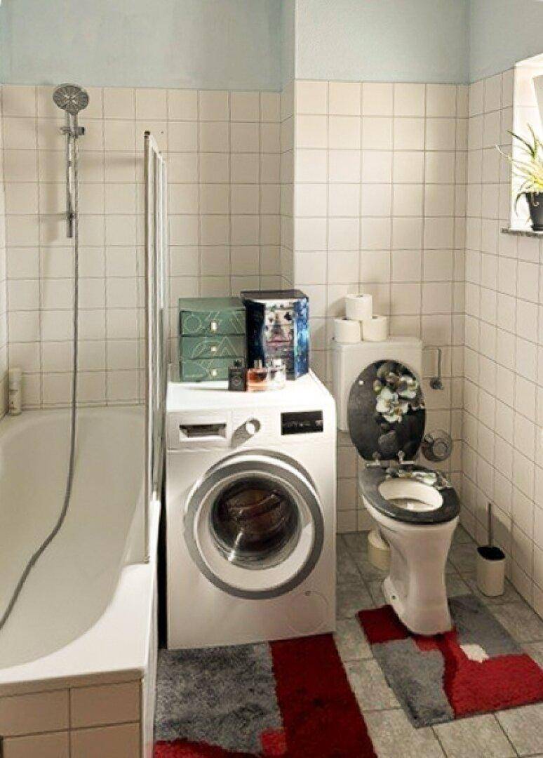 Gefliestes Badezimmer mit Badewanne, Duschvorrichtung und integrierter Waschmaschine.