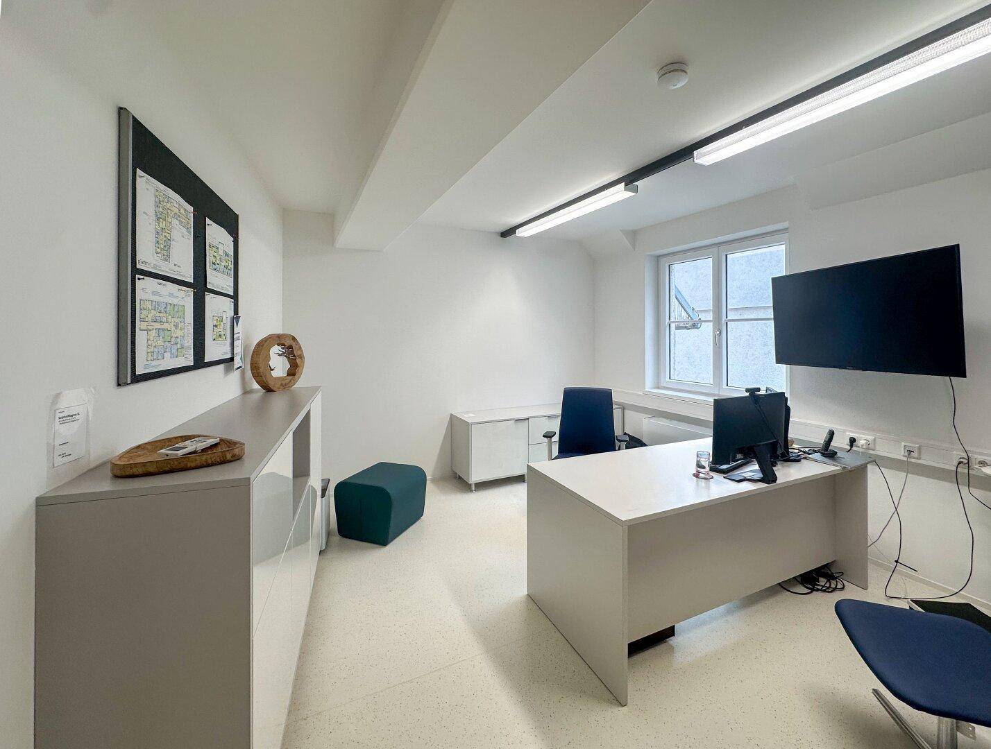 Modernes Einzelbüro mit Schreibtisch, Bürostuhl und Fensterblick.