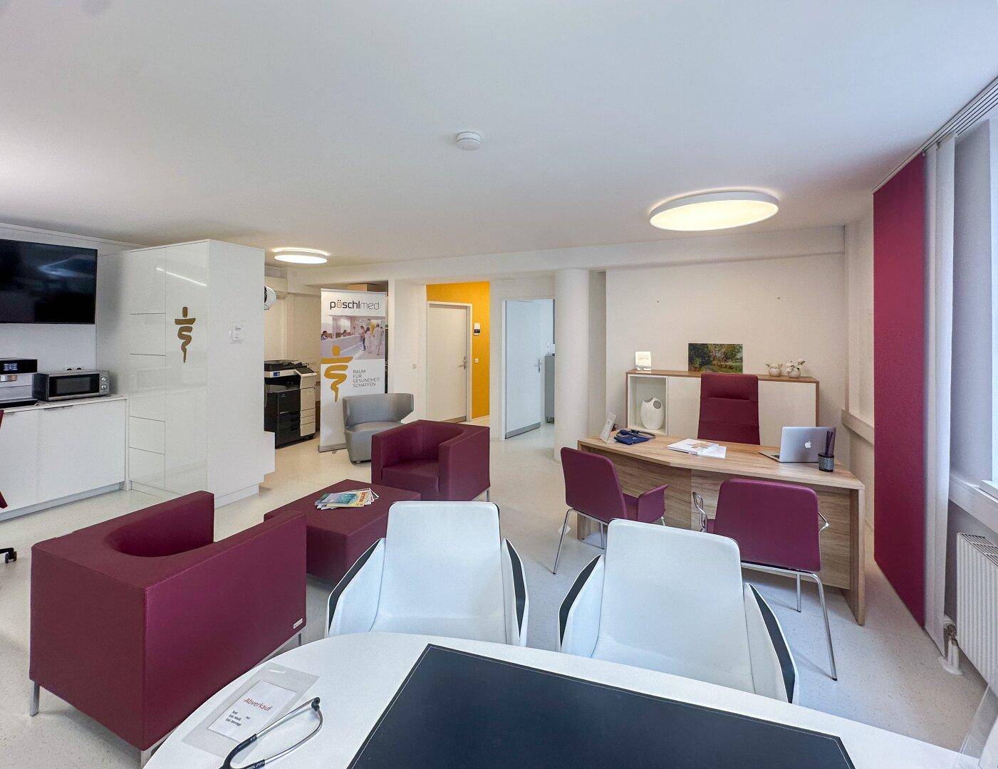 Großzügiges Büro mit Besprechungsbereich, modernen Möbeln und Blick auf den Empfangsbereich.