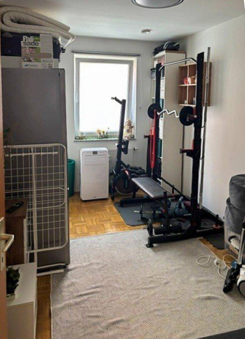 Kleiner Raum, eingerichtet als Fitnessbereich mit Trainingsgeräten und einem Fenster für Tageslicht.