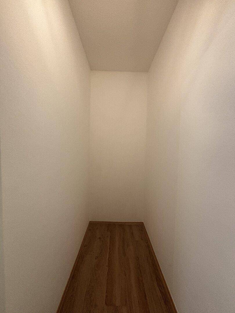Kleiner, leerer Abstellraum mit Laminatboden für zusätzlichen Stauraum.
