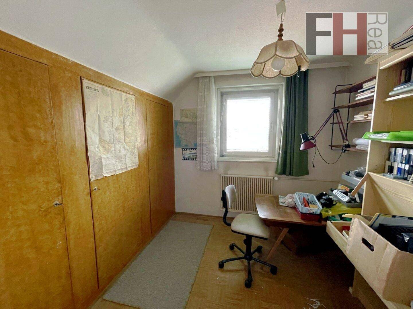 Zimmer mit Einbauschränken, Schreibtisch und Fenster, ideal als Schlaf- oder Arbeitszimmer.
