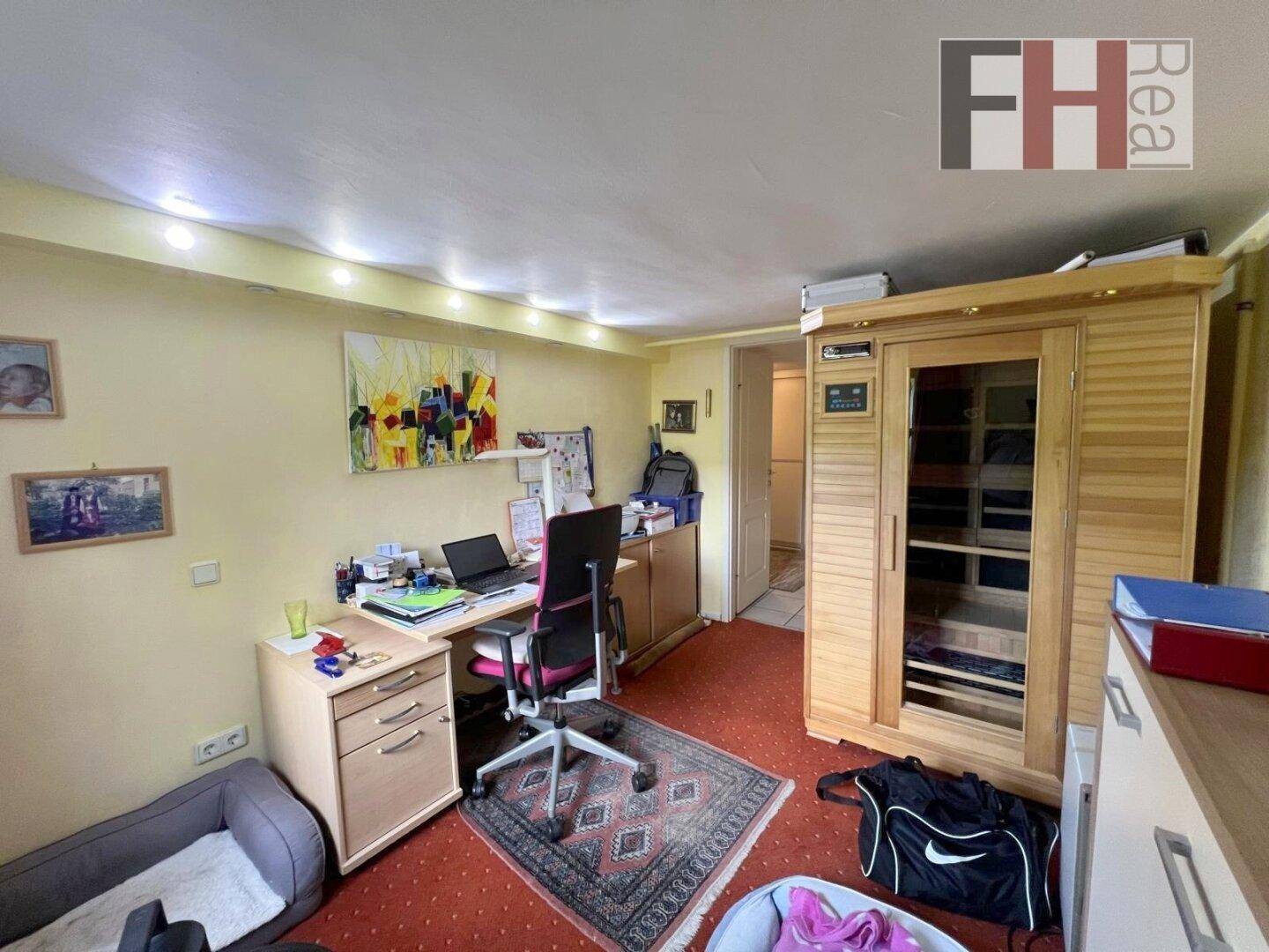 Arbeitszimmer mit Schreibtisch, Bürostuhl und einer integrierten Sauna für Entspannung.