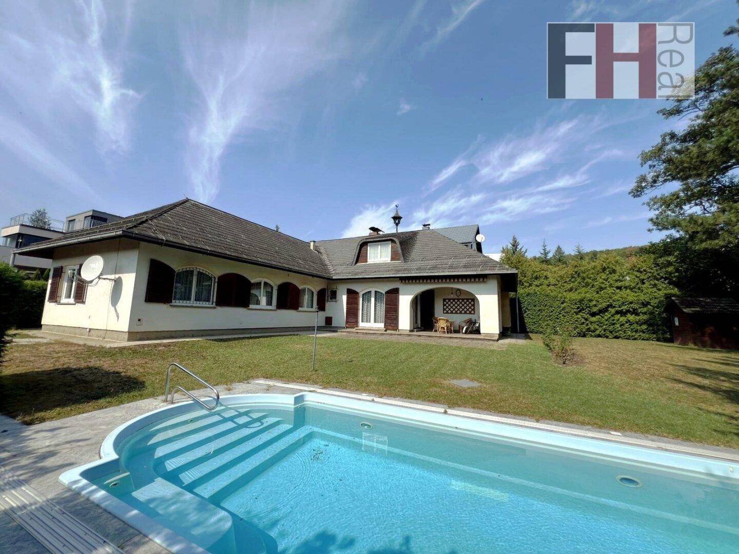Großzügiger Gartenbereich mit Swimmingpool und Blick auf das traditionelle Wohnhaus.