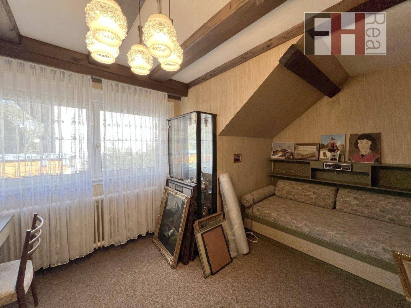 Gemütliches Schlafzimmer im Dachgeschoss mit Schrägen, Fenster und Tagesbett.