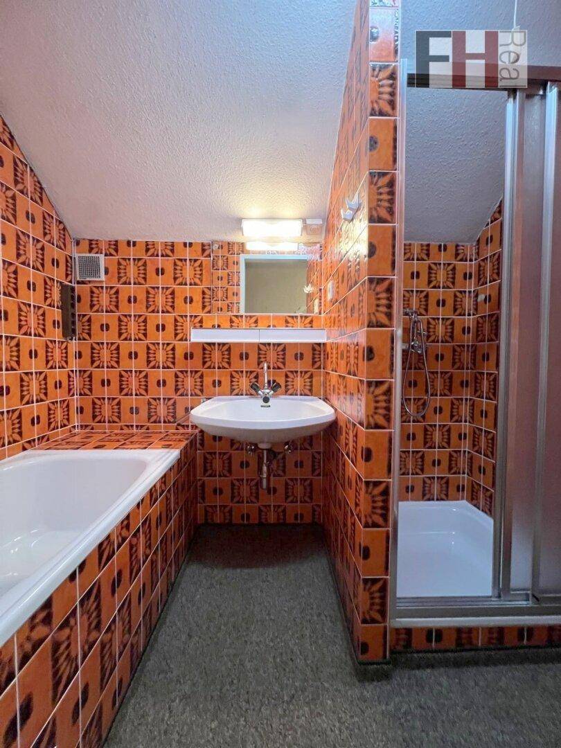 Badezimmer im Retro-Stil mit orangefarbenen Fliesen, Badewanne und Duschkabine.