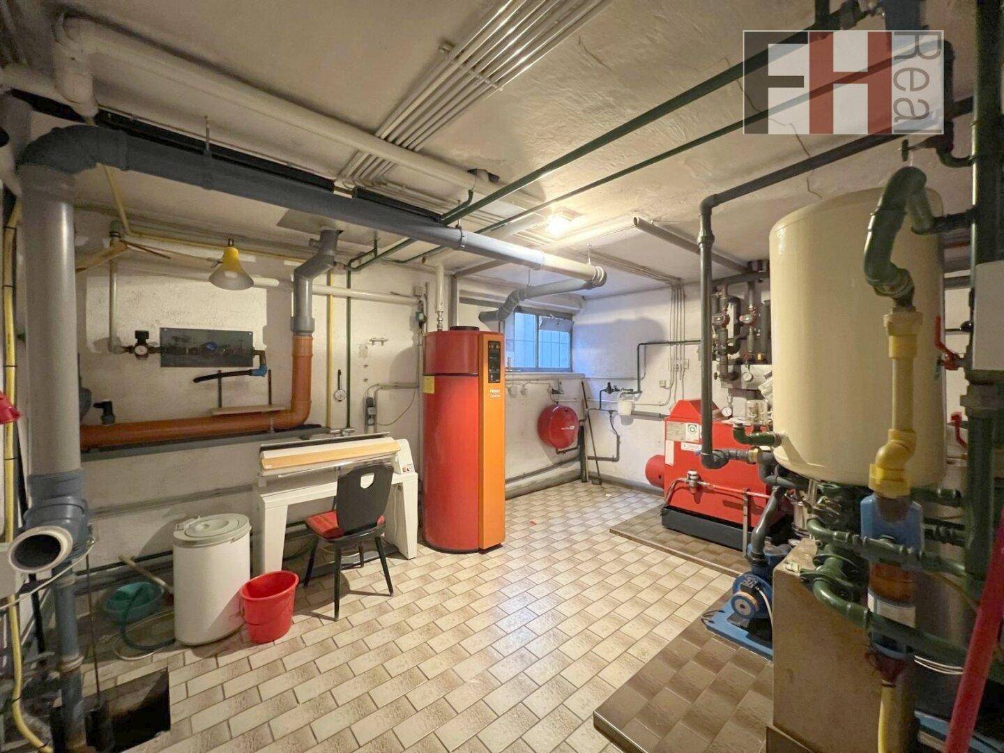Heizungsraum im Keller mit verschiedenen Anlagen und Leitungen.