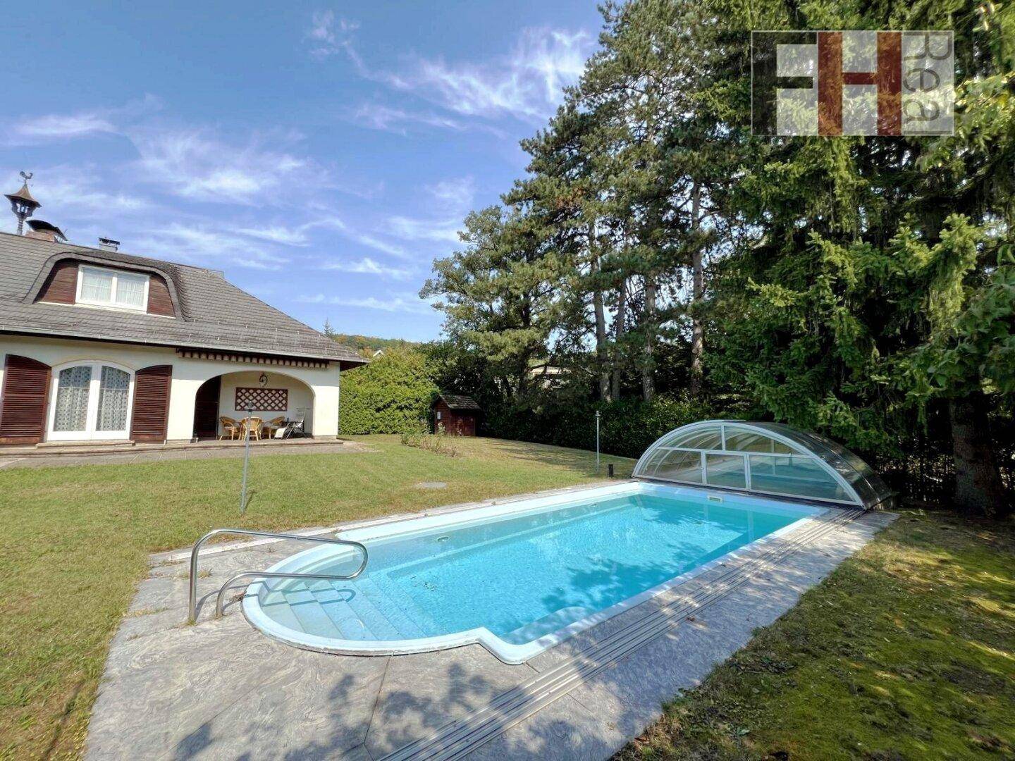 Weitläufiger Garten mit Swimmingpool und Blick auf das charmante Wohnhaus.