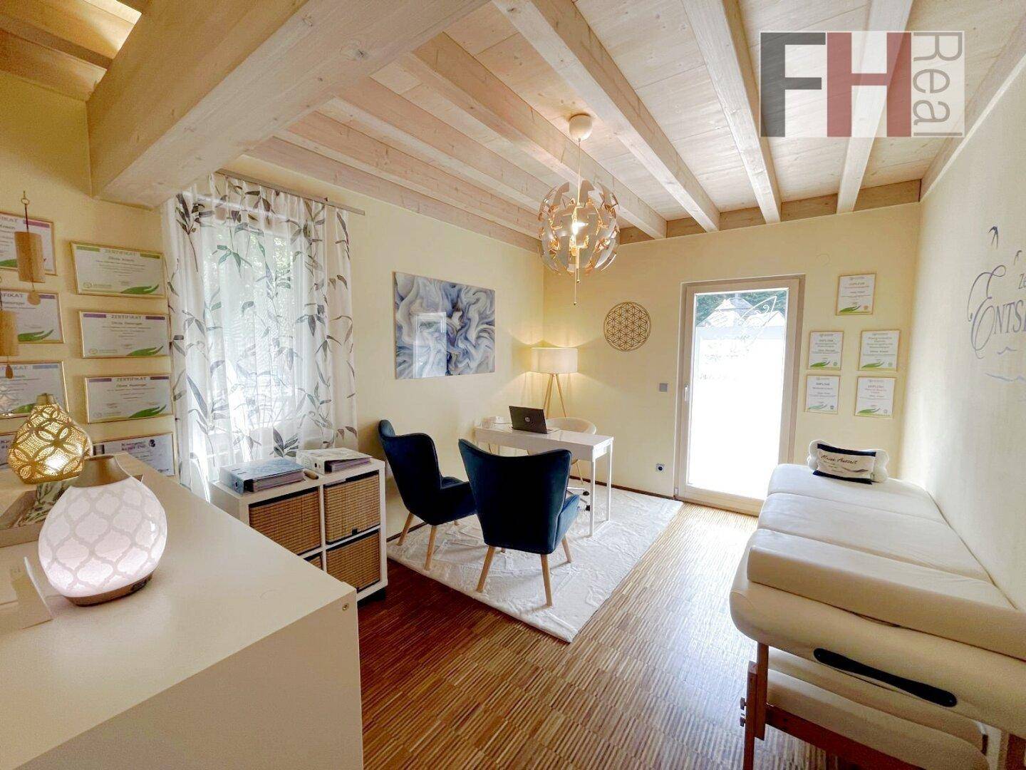 Helles Büro oder Therapieraum mit Holzboden, Holzbalkendecke und Zugang zum Garten.