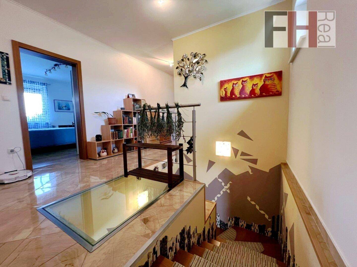 Treppenbereich mit Fliesenboden, Holztreppe und einem interessanten Glasbodenelement.