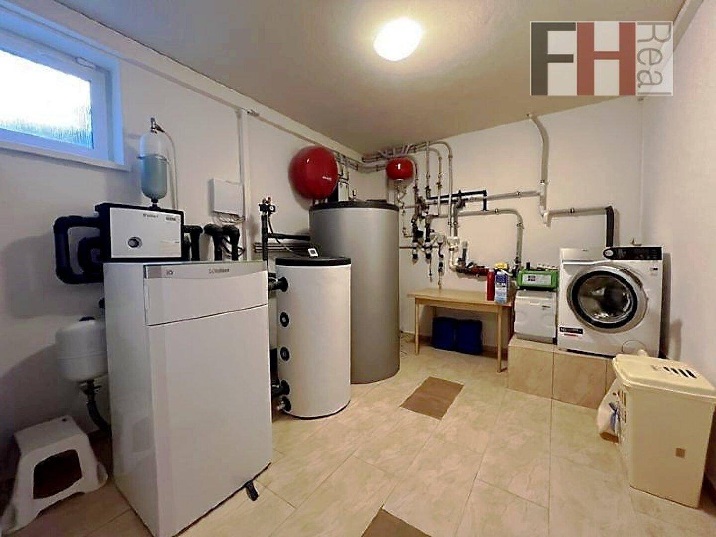 Hauswirtschaftsraum im Untergeschoss mit Heizungsanlage, Waschmaschine und Trockner.