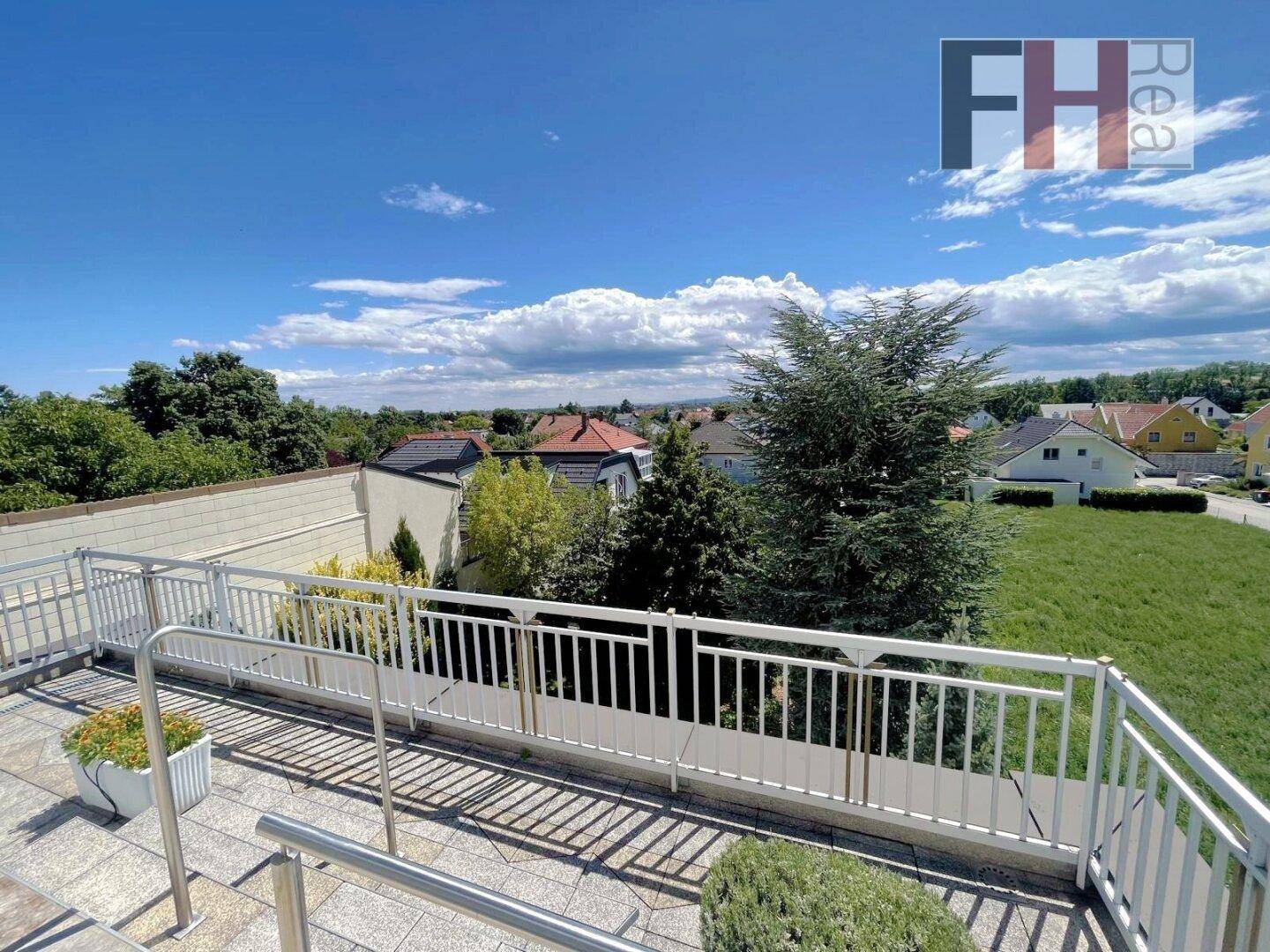 Große Dachterrasse mit weitem Blick über die Umgebung und viel Grün.