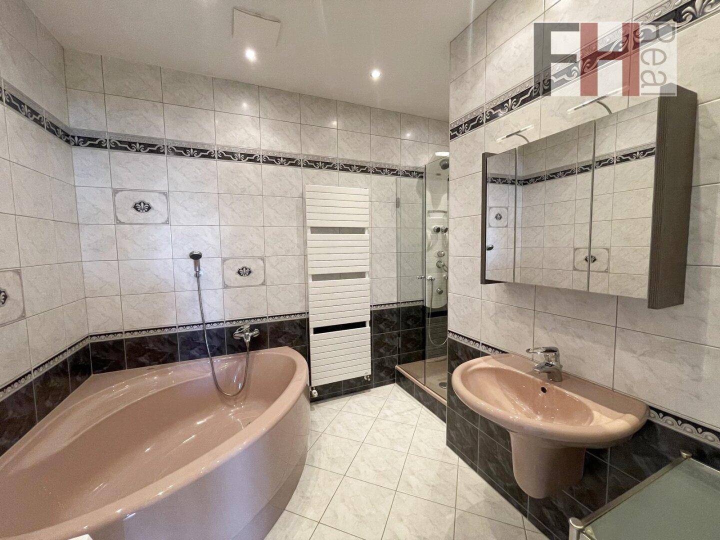Geräumiges Badezimmer mit Eckbadewanne, Dusche und Einzelwaschbecken.