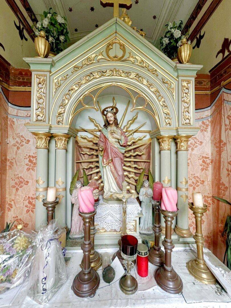 Detailansicht eines reich verzierten Altars mit religiösen Figuren und Kerzen in einem Andachtsraum.