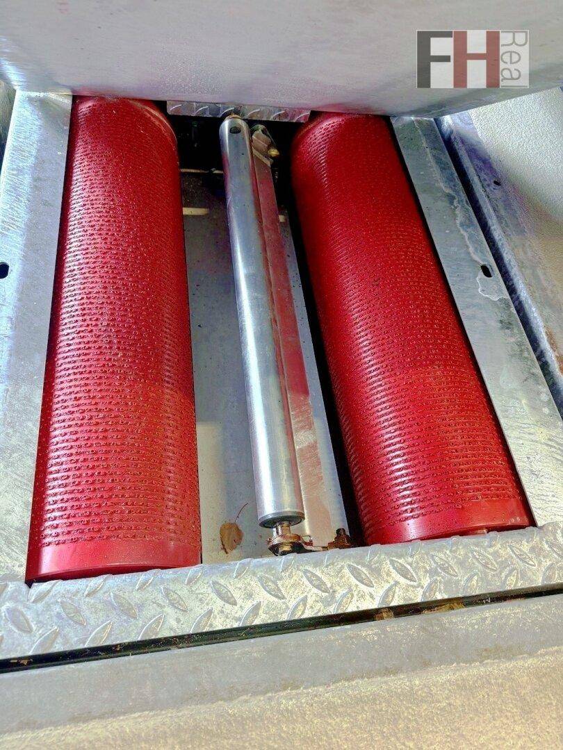 Nahaufnahme einer Fahrzeugprüfstation mit roten Rollen und Metallgittern, die für die Fahrzeugdiagnose verwendet werden.