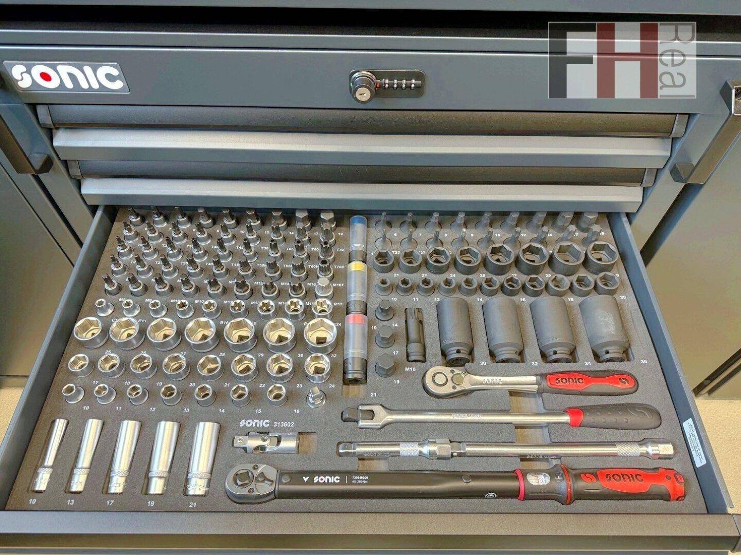 Geöffnete Schublade eines Werkzeugschranks, gefüllt mit einer Vielzahl von Steckschlüsseln und Werkzeugen, ordentlich sortiert.