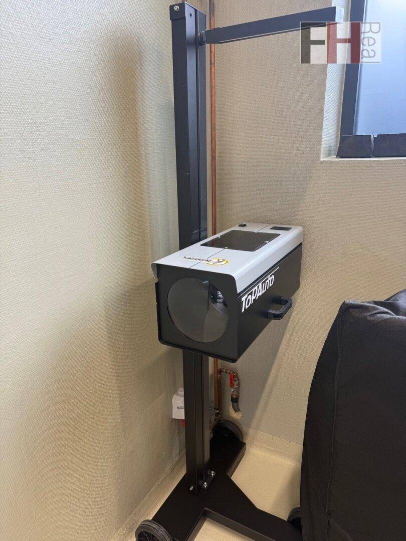 Scheinwerfereinstellgerät auf einem Ständer, bereit für die präzise Überprüfung der Fahrzeugbeleuchtung in der Werkstatt.