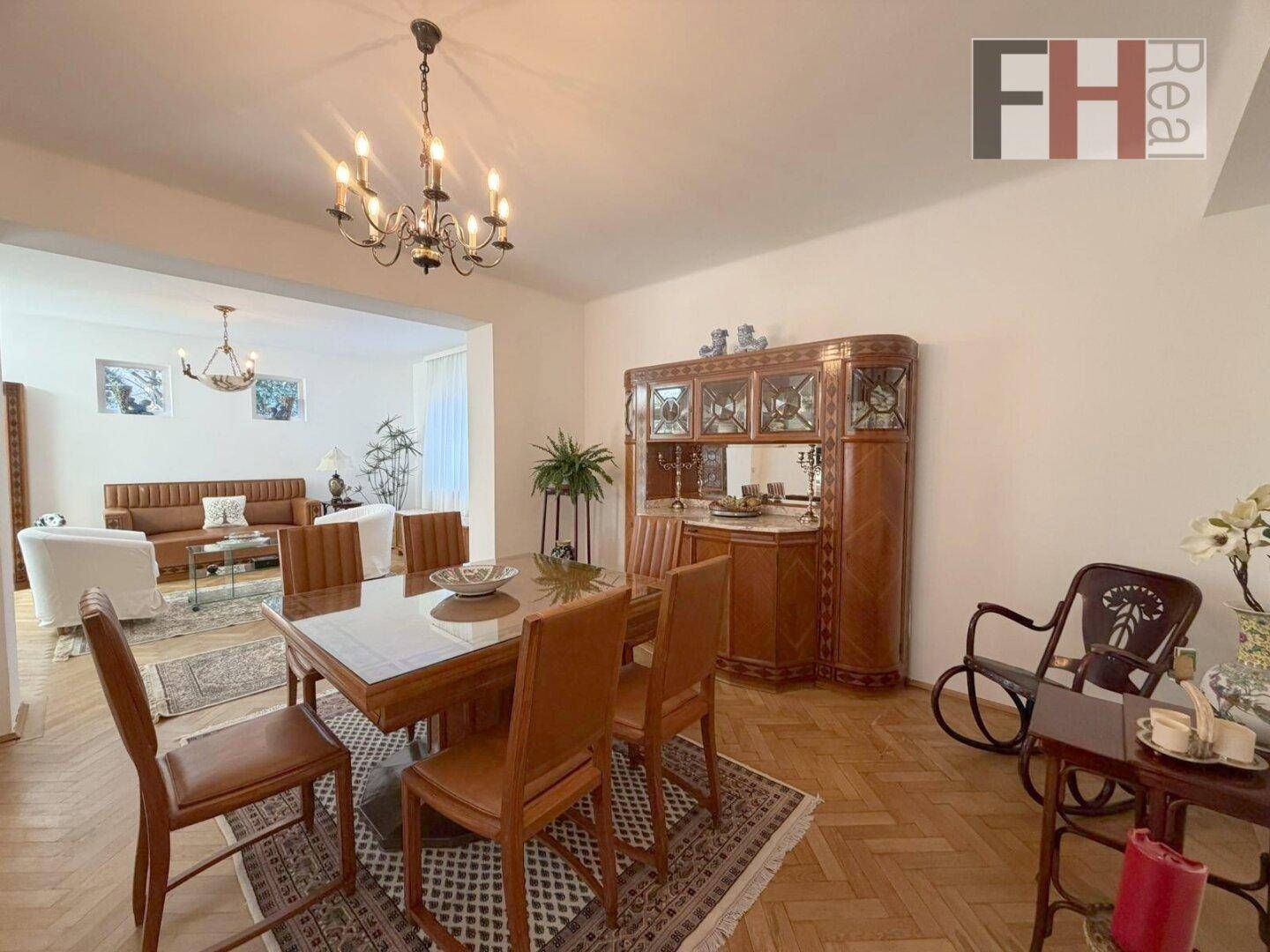 Eleganter Essbereich mit Holztisch, Parkettboden und klassischem Mobiliar.