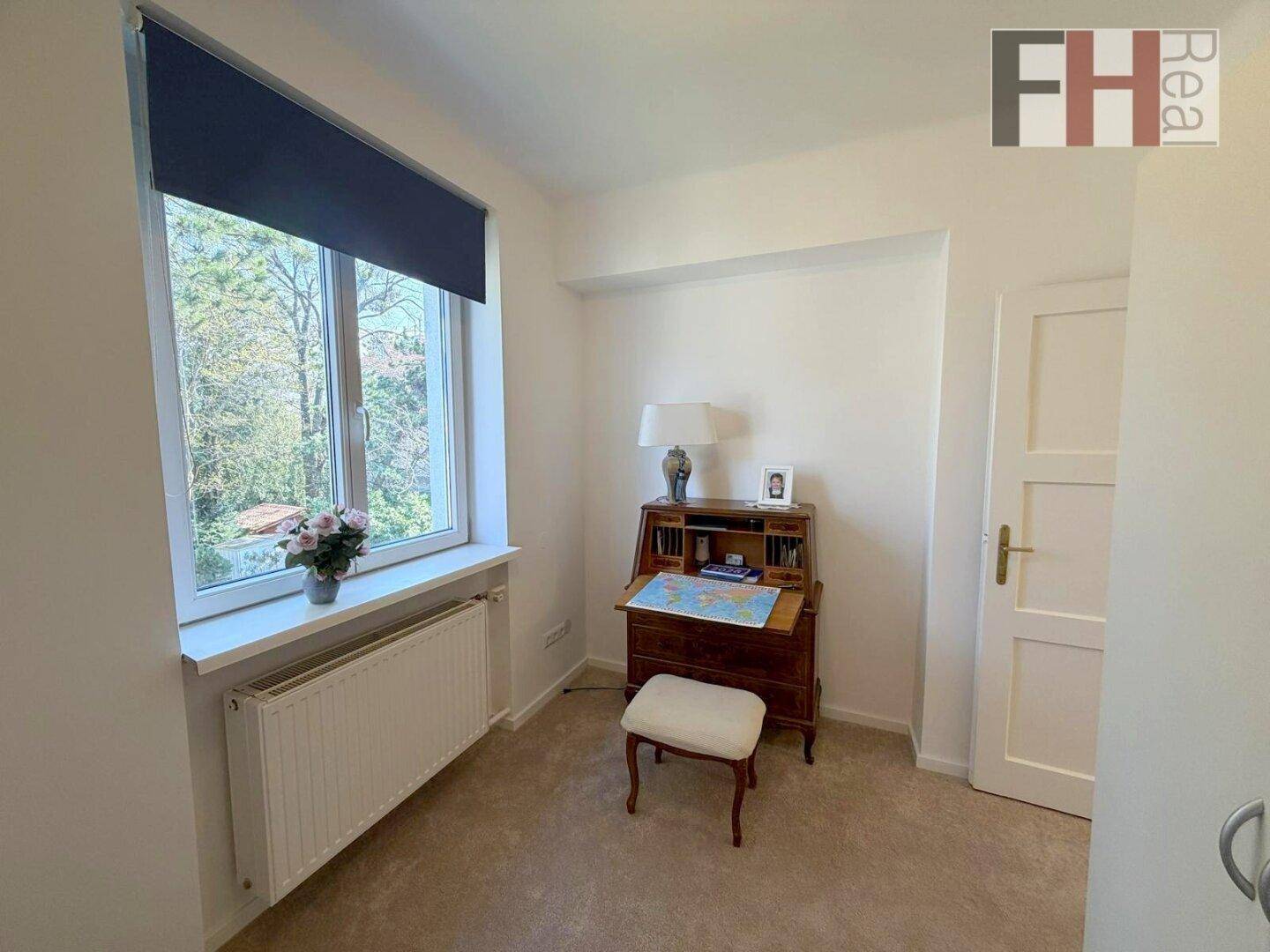 Helles Arbeitszimmer mit Fenster und Blick ins Grüne.