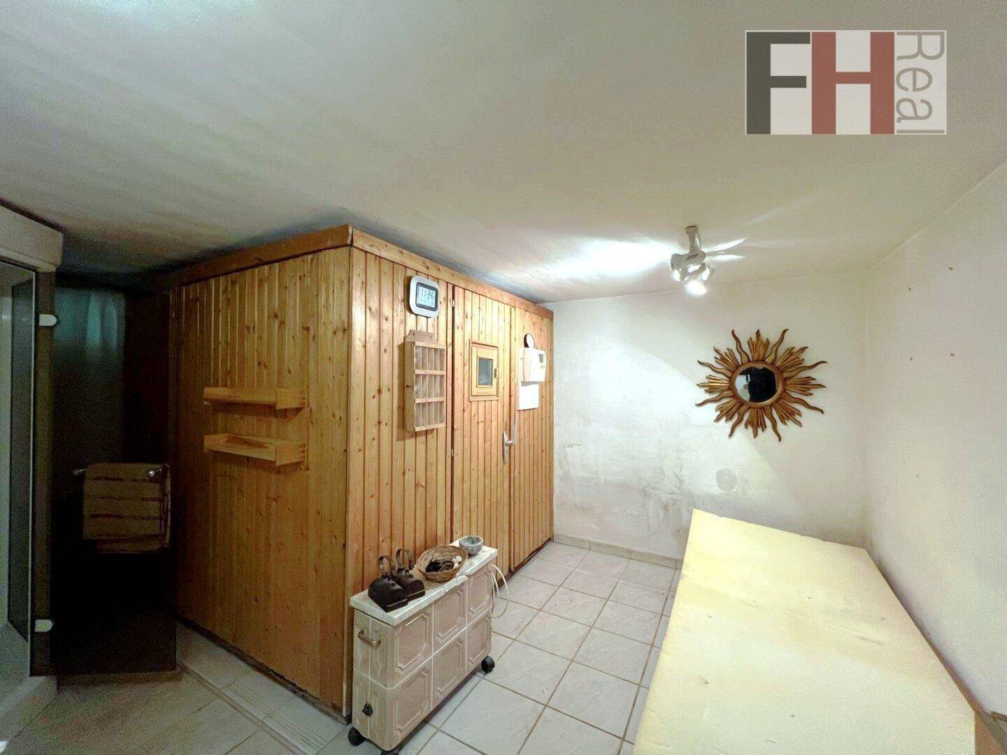 Wellnessbereich im Keller mit Sauna und Liegefläche.