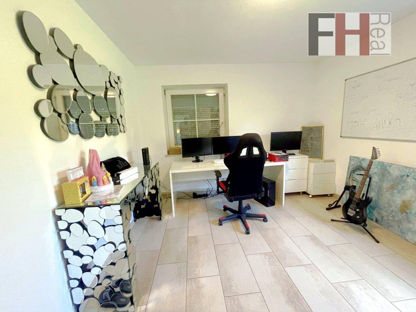 Modern eingerichtetes Büro mit Schreibtisch, Computern und kreativer Wanddekoration.