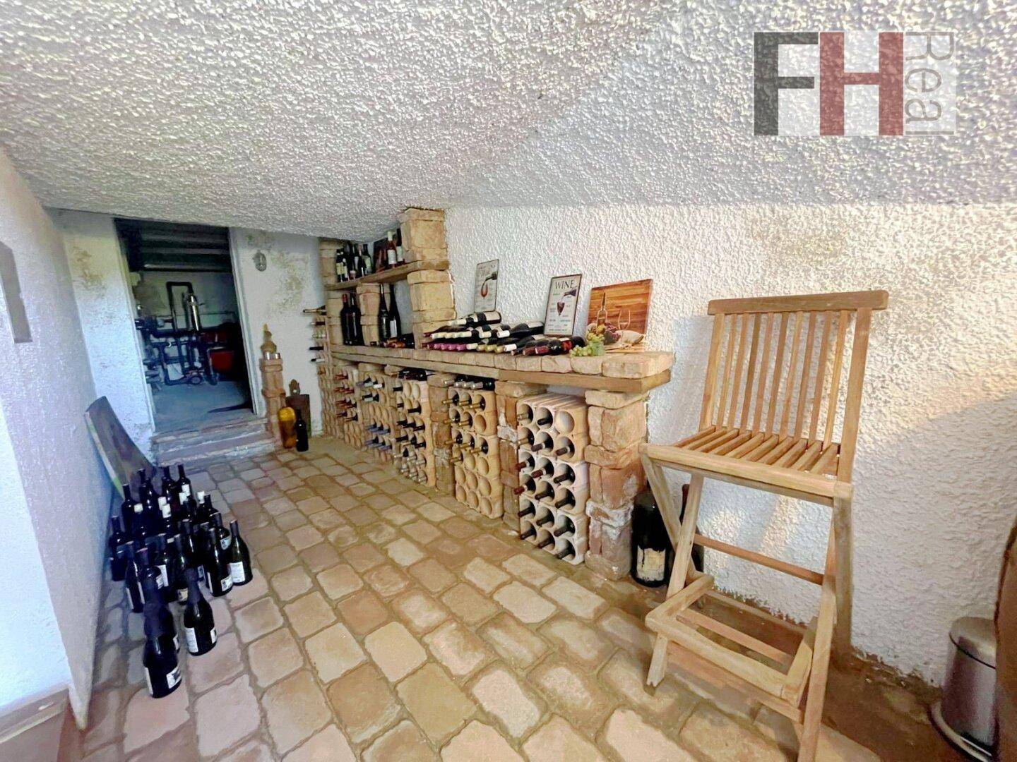 Rustikaler Weinkeller mit Ziegelregalen und zahlreichen Flaschen, ideal für Weinliebhaber.