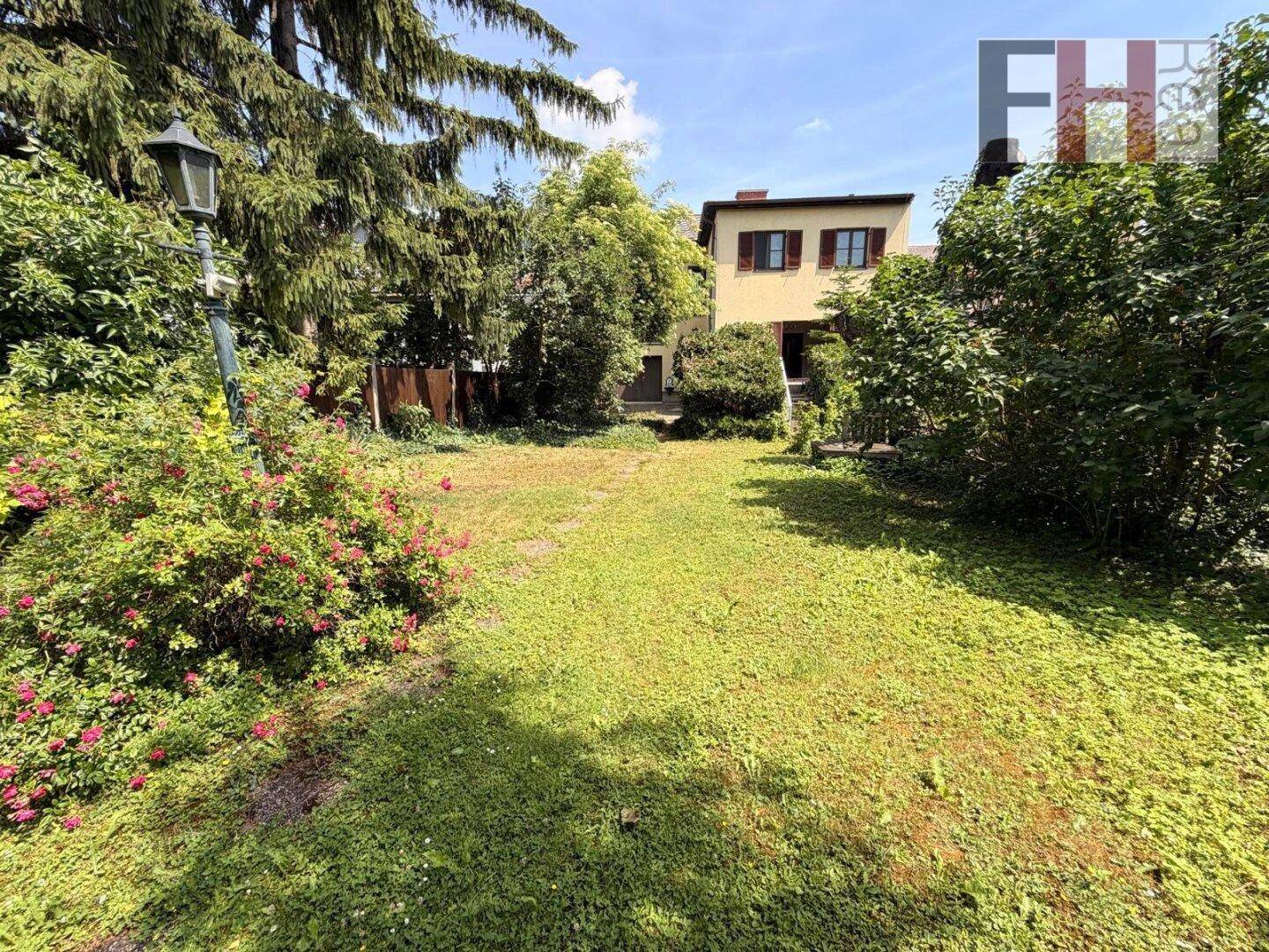 Großer, gepflegter Garten mit weitläufiger Rasenfläche und altem Baumbestand.
