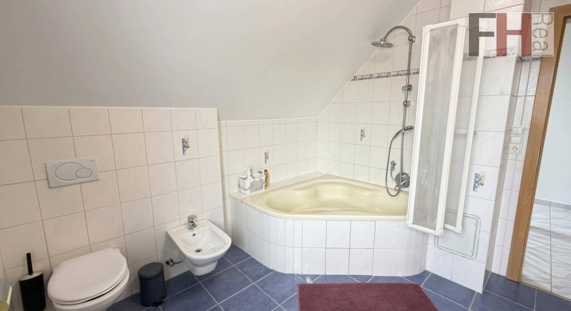 Badezimmer mit Eckbadewanne, Duschbereich, Bidet und WC.