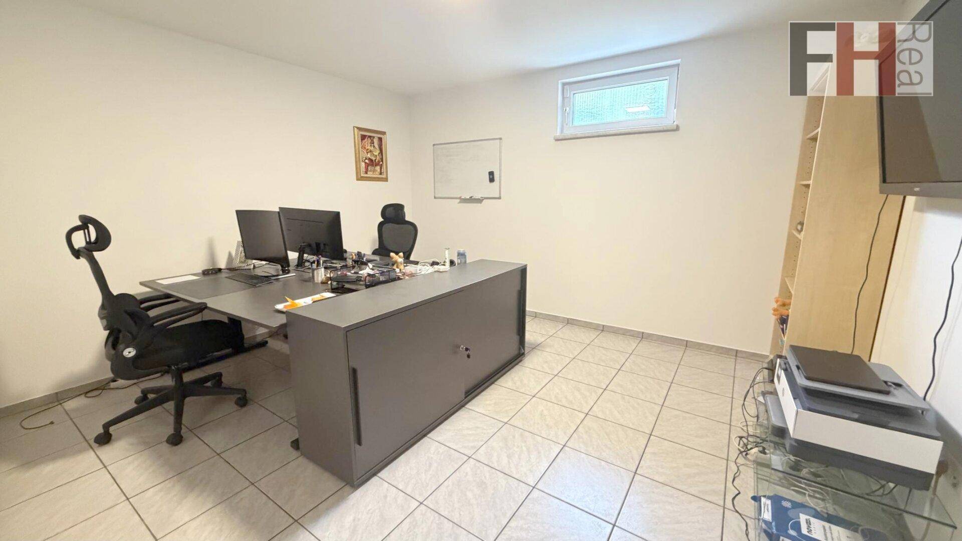 Geräumiges Büro mit mehreren Arbeitsplätzen, Fliesenboden und Fenster.