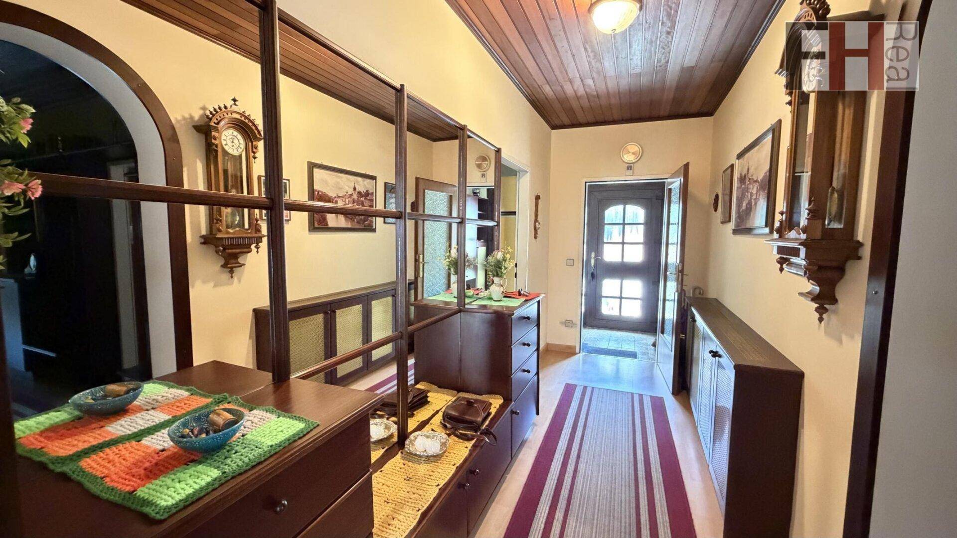 Gemütlicher Flur im Landhausstil mit Holzdecke, Holzboden und traditionellen Möbeln.